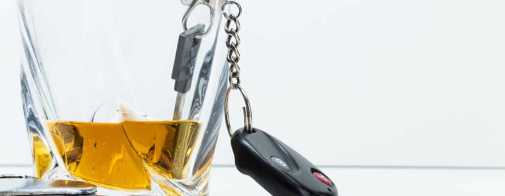 Car key on the bar with spilled alcohol